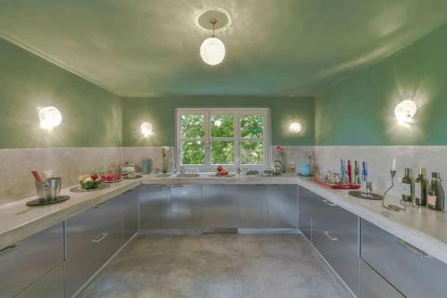 a large kitchen with white cabinets and a window at Villa Zeta / Design Villa with Private Pool in Canelli