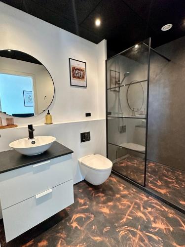 a bathroom with a toilet and a sink and a shower at Torvet17 NR3 - 25m2 in Maribo