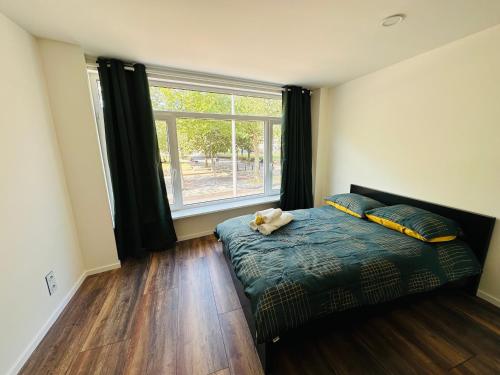 a bedroom with a bed and a large window at Sunshine B&B in Utrecht