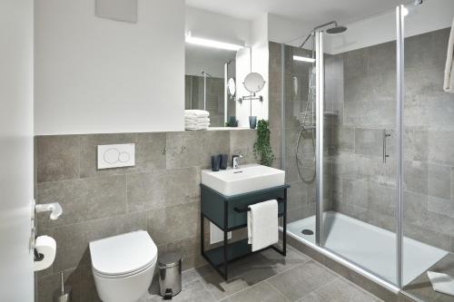 une salle de bain avec un lavabo, des toilettes et une douche dans l'établissement Lüttjeod Apartmentvilla Lüttjeod Apartmentvilla 03, à Langeoog