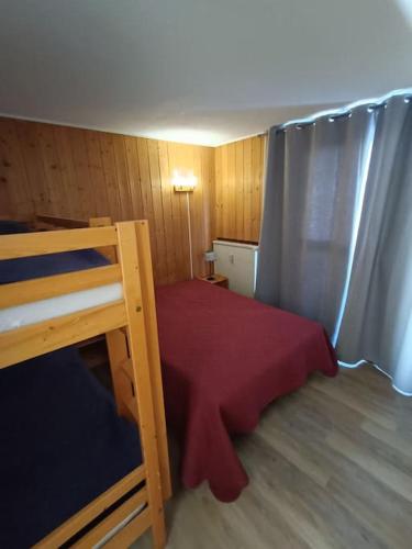 une petite chambre avec un lit avec une couverture rouge dans l'établissement SUPERBE T2 TRAVERSANT- 6PERS - VAL CLARET, à Tignes