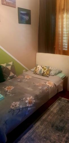 a bedroom with a bed with flowers on it at Guest House Cinderella in Herceg-Novi