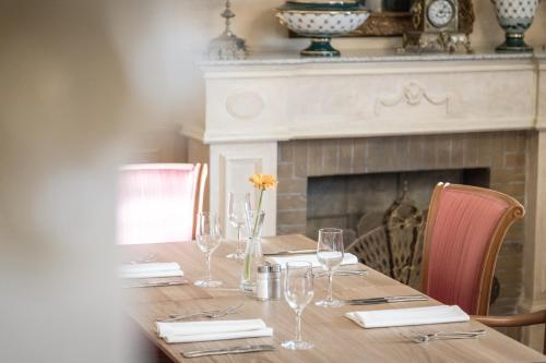 a wooden table with wine glasses and a fireplace at Hotel Donauhof in Deggendorf