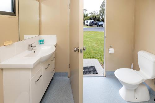 a bathroom with a white sink and a toilet at BIG4 Hobart Airport Tourist Park in Cambridge