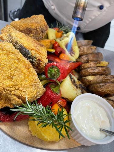 a plate of food with meat and vegetables and sauce at Melin Residence in Orşova