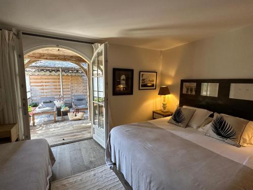 Schlafzimmer mit einem Bett und einer Tür zu einer Terrasse in der Unterkunft Le Clos des Sept Palmiers in Cavalaire-sur-Mer