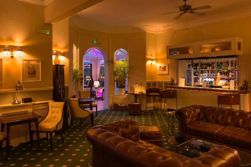 a living room with leather furniture and a bar at Riviera Lodge Hotel in Torquay