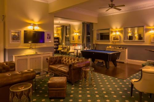 a living room with couches and a pool table at Riviera Lodge Hotel in Torquay