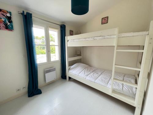 een slaapkamer met 2 stapelbedden en een raam bij FLORENTINE maison au calme proche du Port in Saint-Martin-de-Ré