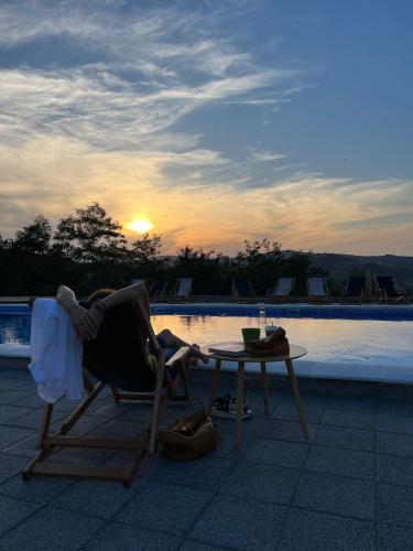 a person sitting in a chair next to a table at Zdravkovac Country Club - Hotel in Topola