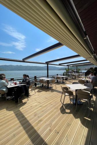 people sitting at tables on the deck of a boat at Melin Residence in Orşova