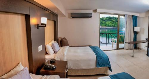 a hotel room with a bed and a balcony at The Beach House in Panama City