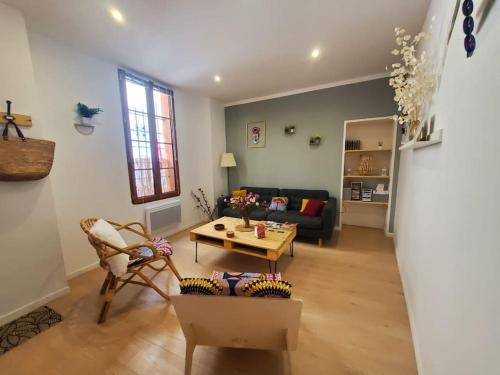 a living room with a couch and a table at La Louve - maison de ville in Narbonne