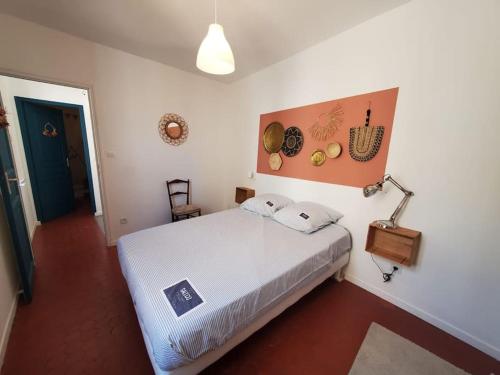 sypialnia z dużym białym łóżkiem i lampką w obiekcie La Louve - maison de ville w mieście Narbona