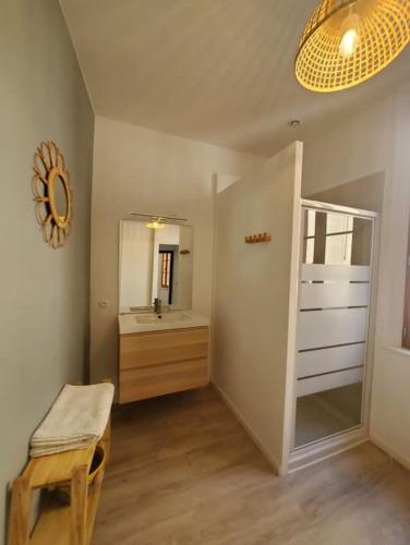 une salle de bain avec un lavabo et un miroir dans l'établissement La Louve - maison de ville, à Narbonne