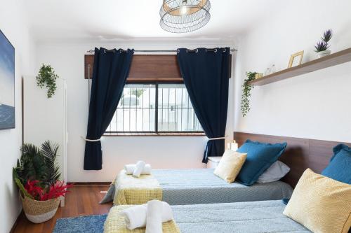 1 Schlafzimmer mit 2 Betten und einem Fenster in der Unterkunft Comfy Bright Flats with Netflix in Porto