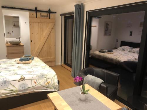 1 dormitorio con 2 camas, mesa y espejo en Au Mas de Mont, en Yvoir
