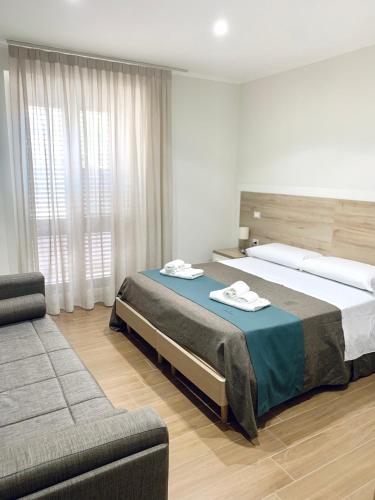 a bedroom with a large bed and a couch at Tempio Aurora in San Costantino Albanese