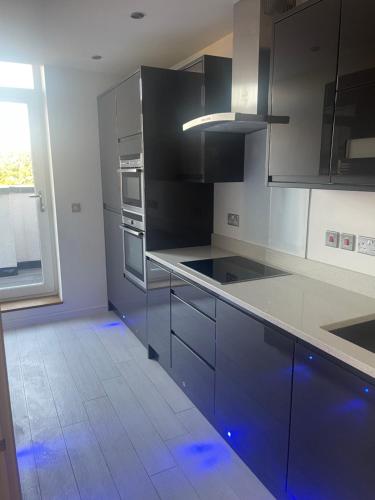 a kitchen with black and white cabinets and a window at Luxury 2 Bed 2 Bath Penthouse Apartment in Hendon