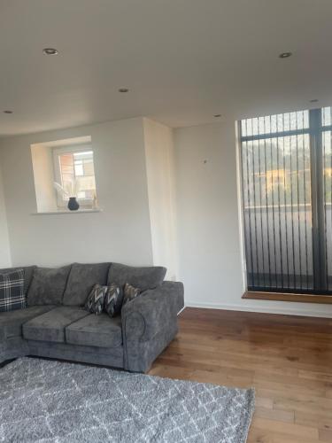 a living room with a couch and a large window at Luxury 2 Bed 2 Bath Penthouse Apartment in Hendon