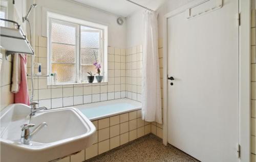 a bathroom with a tub and a sink and a window at Beautiful Home In Gudhjem With 3 Bedrooms And Wifi in Gudhjem