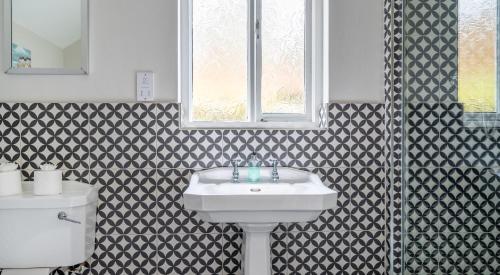 a bathroom with a sink and a toilet at Keepers Cottage in Rusland