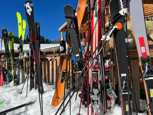 Un montón de esquís están alineados en la nieve en Schifer Berghaus, en Klosters