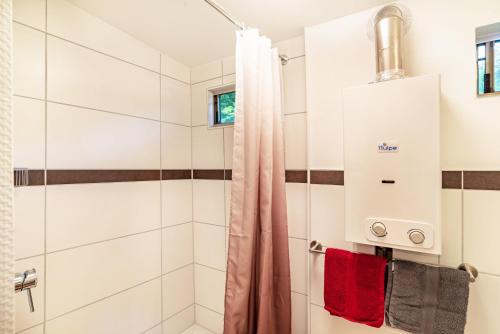 een badkamer met een douche en rode handdoeken bij Haus am Bach in Schönmünzach