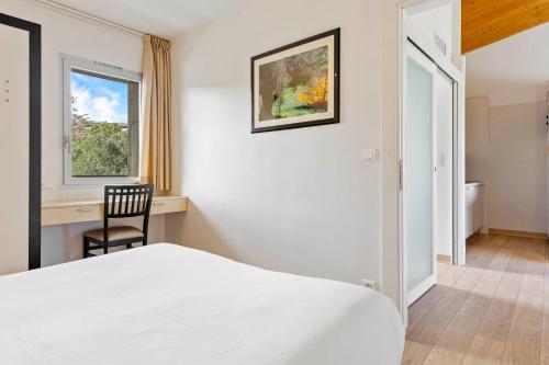 - une chambre avec un lit, une chaise et une fenêtre dans l'établissement Résidence Cala Sultana Appartement T2, à Porto-Vecchio