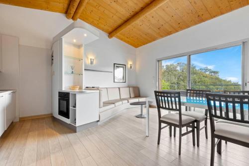 une cuisine et une salle à manger avec une table et des chaises dans l'établissement Résidence Cala Sultana Appartement T2, à Porto-Vecchio
