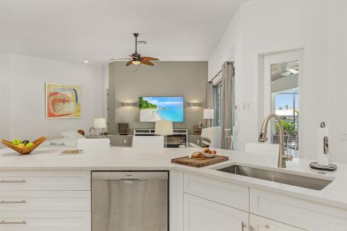 een witte keuken met een wastafel en een tv bij LUXURY VILLA AWENASA * experience the vacation of your dreams in Cape Coral