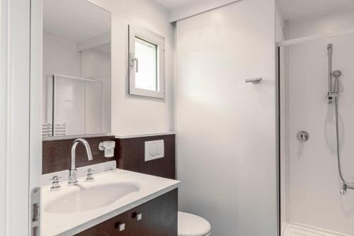 La salle de bains est pourvue d'un lavabo, de toilettes et d'une douche. dans l'établissement Résidence Cala Sultana Appartement T2, à Porto-Vecchio