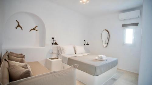 a white room with a bed and a couch at Gaia Mykonos Villas & Suites in Tagou