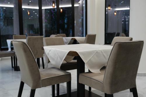 a dining room with a white table and chairs at The Honeycomb Boutique Hotel in Golem