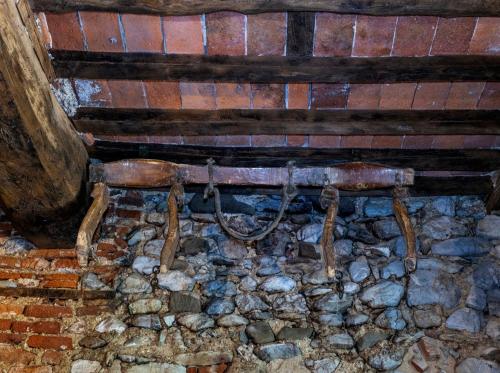an old bench in a room with rocks at Frantoio Del Moscatello in Camaiore