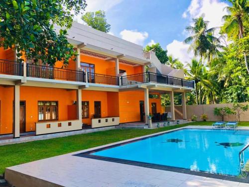 a house with a swimming pool in front of it at Saayoo Resort in Negombo