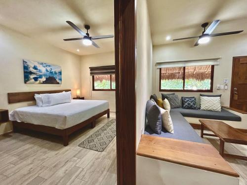 a bedroom with a bed and a couch at Aldea Xaan Ha Tulum in Tulum