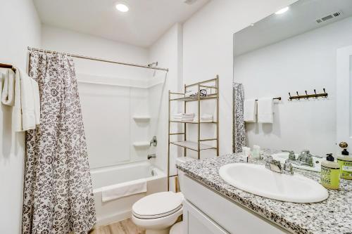 a white bathroom with a sink and a toilet at Staycation Cottage in San Antonio