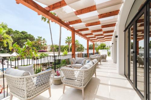 an outdoor patio with wicker chairs and tables at Boutiquehotel El Coto in Colonia Sant Jordi