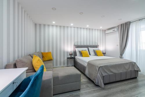 ein Schlafzimmer mit einem Bett und einem Sofa in der Unterkunft Small, sweet & cosy apartments in Rijeka