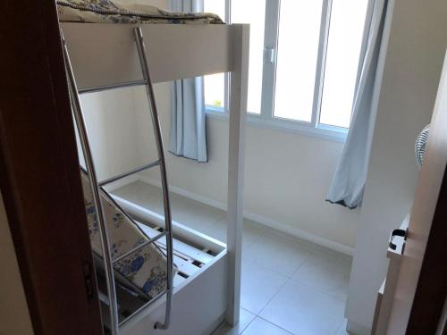- un réfrigérateur vide dans une chambre avec fenêtre dans l'établissement Apartamento a 150 metros do mar, à Governador Celso Ramos