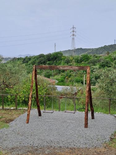 um baloiço de madeira em cima do cascalho em IL CASALE em Santa Lucia del Mela