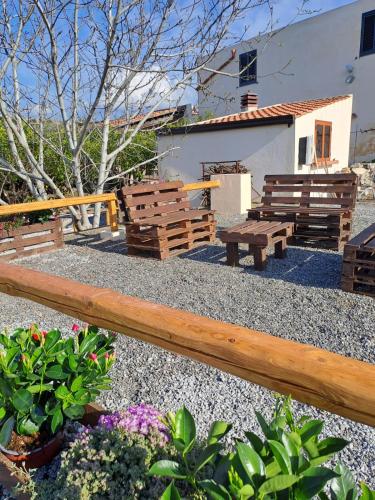 un grupo de bancos de madera sentados en un patio en IL CASALE en Santa Lucia del Mela