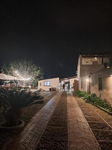 um grupo de pessoas andando por uma rua à noite em IL CASALE em Santa Lucia del Mela