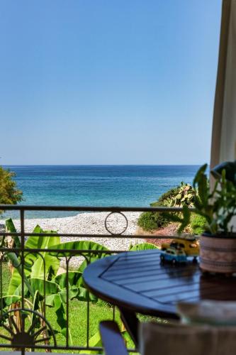 a view of the ocean from a balcony with a table at Malsova Maisonette in Kotrónion