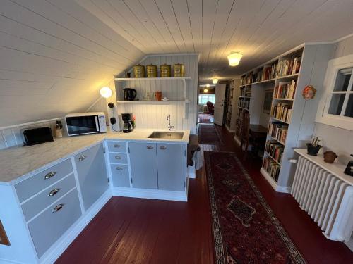 uma cozinha com armários brancos e um lavatório num quarto em Villa Wäring Husrum & Frukost em Varberg