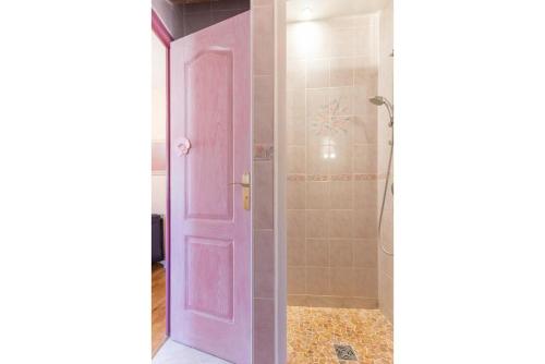 uma porta rosa numa casa de banho com um chuveiro em La Villanelle 