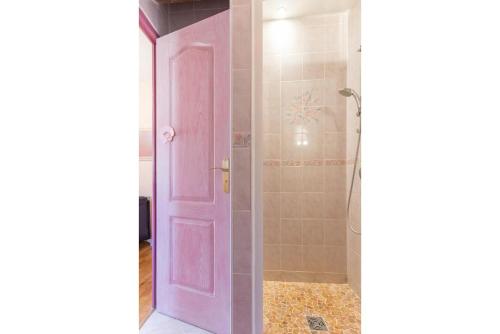 a pink door in a bathroom with a shower at La Villanelle 
