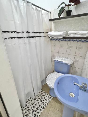 a bathroom with a toilet and a blue sink at Margarita's room in Morales