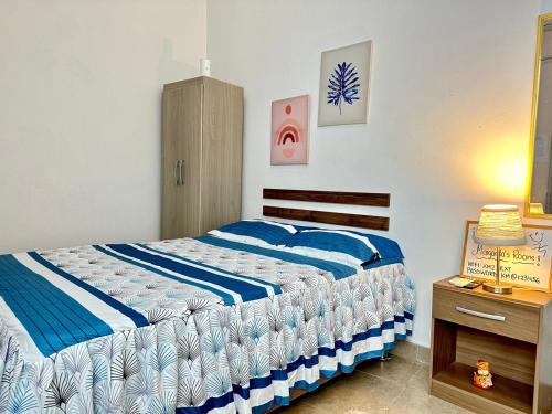 a bedroom with a bed with blue and white sheets at Margarita's room in Morales